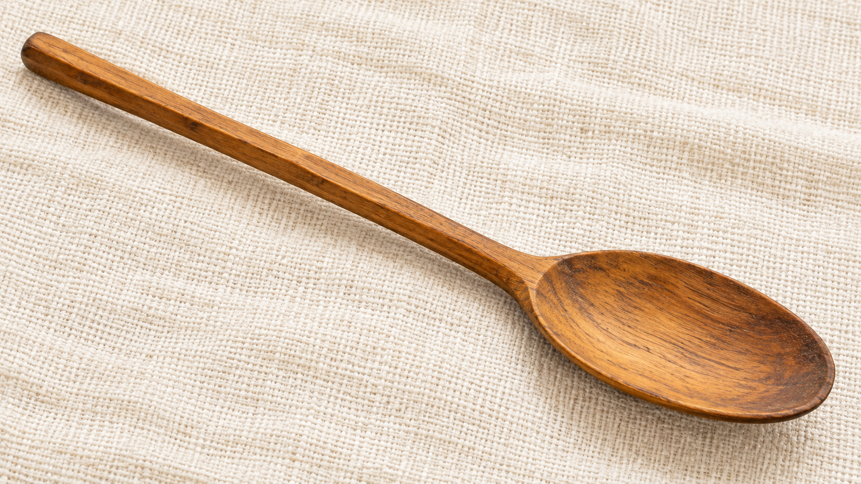 Bright illustration of a Somali Fandhaal wooden eating spoon on cream woven cloth